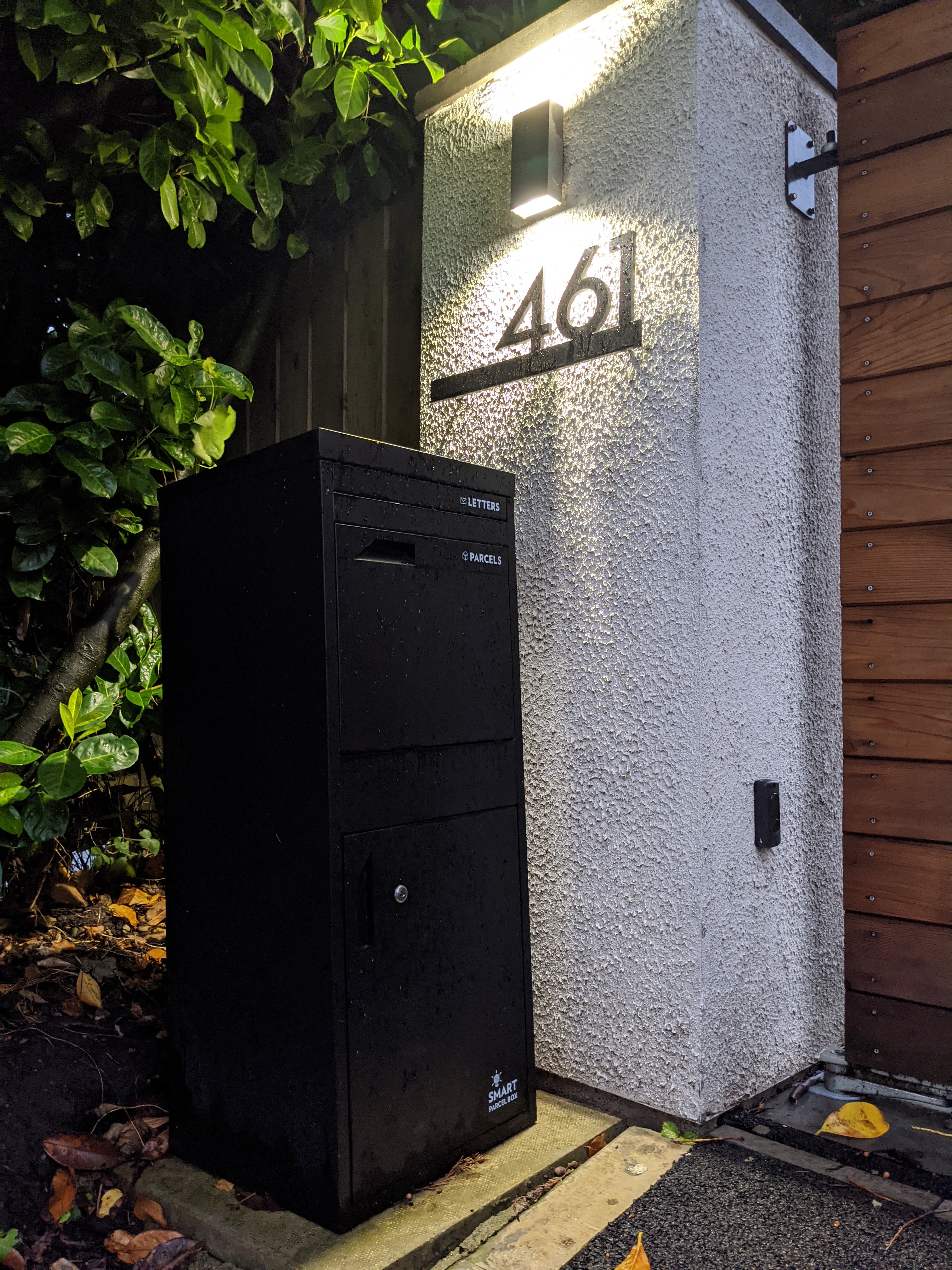 Black parcel drop box in the drive of a house